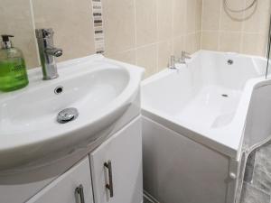 een badkamer met een witte wastafel en een witte kast bij Winterbrook Cottage in St Austell +25 foto's