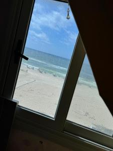 uma vista para a praia a partir de uma janela em Family Condo With Panoramic Sea View 2 em Alexandria