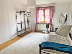 1 dormitorio con 1 cama y una ventana con cortinas rosas en Ferienwohnung Sankt Martin 225 N.N., en Sankt Martin