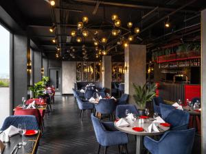 a restaurant with tables and chairs and a bar at Radisson RED London Gatwick Airport in Crawley