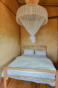 Łóżko w pokoju z moskitierą w obiekcie FRAMA ECO LODGE, Twin Lakes (big island)- Lake Burera 
