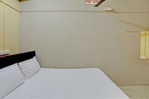 Un pequeño dormitorio con una cama blanca en una habitación en Hotel Manisha Palace, en Sehore