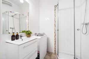 un bagno bianco con lavandino e doccia di Vistula River Apartment a Cracovia Altre 25 foto