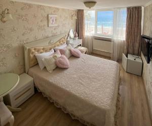 - une chambre avec un lit doté d'oreillers roses et d'une fenêtre dans l'établissement Shalanda, à Odessa