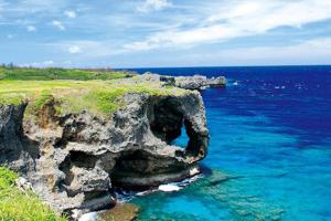 a rock formation in the ocean next to the water at Mishuku Onna 203 in Onna