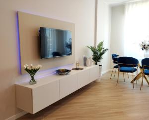 a living room with a tv on a white cabinet at Blue Sea Apartment in Torvaianica