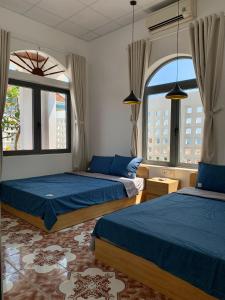 2 Betten in einem Zimmer mit 2 Fenstern in der Unterkunft Homestay Beach View 2 in Phú Hiệp