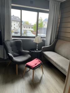 un soggiorno con divano, sedie e finestra di New Apartment 2 bedroms a Stryn