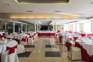 a banquet hall with white tables and red chairs at AGH Canet in Canet de Berenguer