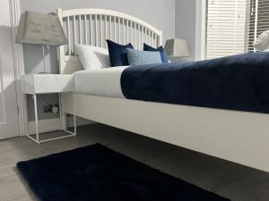 レインハムにあるPointcastle1のベッドルーム(白いベッド、青い枕付)