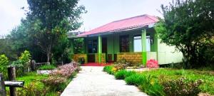 ein kleines Haus mit rotem Dach und Garten in der Unterkunft Abode Me Me Ai Haven in Cherrapunji