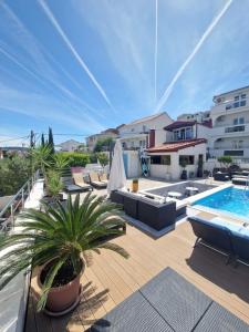 eine Terrasse mit Stühlen und einem Pool in der Unterkunft Apartments Silva in Trogir