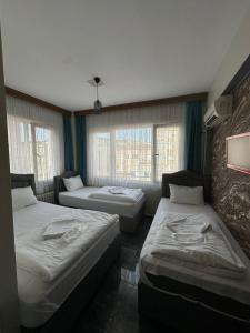 a room with two beds and two windows at HİSAR HOTEL in Istanbul