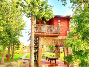 ein Baumhaus mit Balkon darüber in der Unterkunft Chahal Tree Farm House - 20 min Ride from Golden Temple in Amritsar