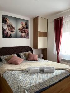 a bedroom with a large bed with two pictures on the wall at Apartman Akiluz & SPA Zlatibor in Zlatibor