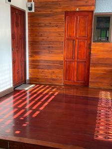 um quarto vazio com uma porta de madeira e um piso de madeira em บ้านเรา แอท น่าน em Nan