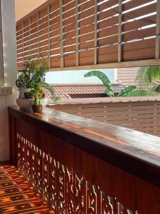 - un bar en bois avec des plantes à côté d'une fenêtre dans l'établissement บ้านเรา แอท น่าน, à Nan