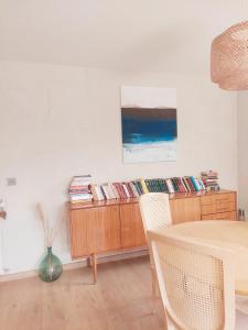 a dining room with a table and a shelf of records at Villa entière avec jardin in Aix-les-Bains