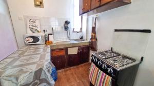 a small kitchen with a stove and a microwave at Gee's Holiday Home Apartment in Mombasa CBD - Parking in Mombasa