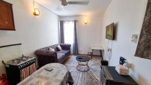 un soggiorno con divano e tavolo di Gee's Neat Apartment in Mombasa CBD / Parking 2 a Mombasa
