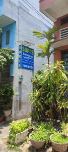 a sign on the side of a building with plants at Suri's Homestay in Quy Nhon