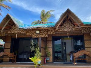 a resort building with a blue roof and glass doors at Residencia Gemma in Siquijor