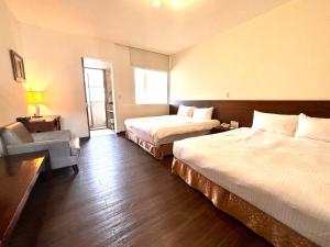 a hotel room with two beds and a chair at LIDO FORESTRY SPA RESORT in Yangmei