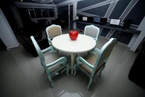 a white table with four chairs and an apple on it at Hotel San Marcos Barranquilla in Barranquilla