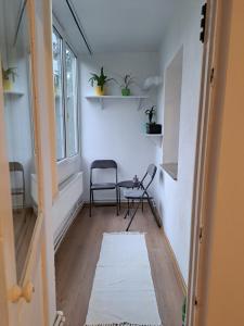 um corredor com duas cadeiras, uma mesa e uma janela em DÉNY APARTMAN em Sfântu Gheorghe