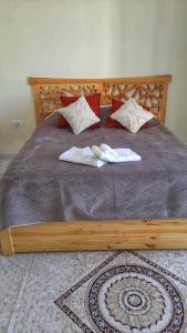 a wooden bed with two white towels on it at Monastir Bord de Mer Palais Présidentiel in Monastir