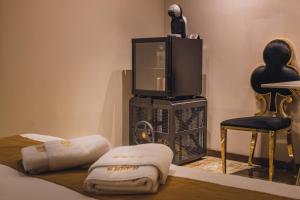 a room with a bed and a tv and a chair at HIDDEN BANK: Golden in Plovdiv