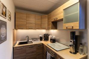 a kitchen with wooden cabinets and a counter top at Ferienwohnung Haus am See in Kaufungen