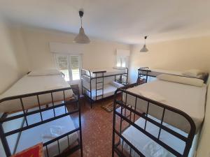 a room with three bunk beds in it at Hostel Pilgrim's in Navarrete