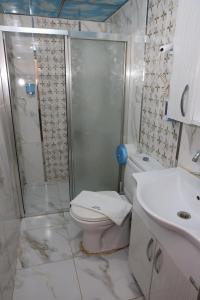 uma casa de banho com um chuveiro, um WC e um lavatório. em Adana Saray Hotel em Adana