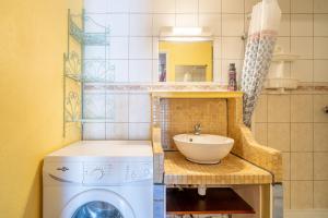 a bathroom with a washing machine and a sink at Maison Fleurynes in Fleury +15 photos