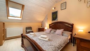 a bedroom with a bed with towels on it at Kútvölgy Vendégház in Vác +35 photos