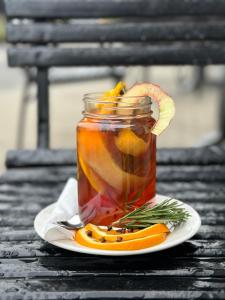 a jar of tea with oranges and rosemary on a plate at Hotel Lamberton in Ołtarzew