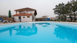 una piscina de agua azul frente a una casa en Quinta do Esteval, en Penacova
