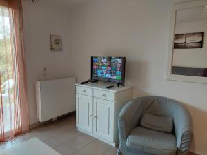 un soggiorno con una sedia e una televisione su un mobile di Lavandoule a Gréoux-les-Bains