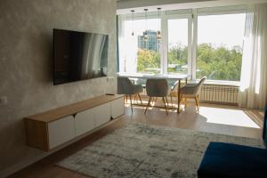 a living room with a television and a table and chairs at Central City Park Panorama View in Chişinău