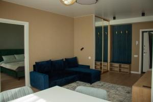 a living room with a blue couch and a bed at Central City Park Panorama View in Chişinău +49 photos