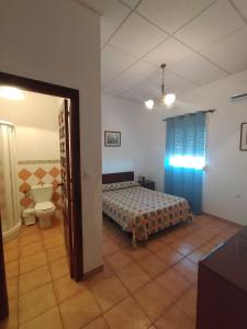 um quarto com uma cama e um WC num quarto em Finca La Tacita - Petunia em Conil de la Frontera