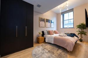 a bedroom with a bed and a large black cabinet at Charlotte House Residence by COQOON in Manchester
