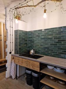 a kitchen with a sink and a green tile wall at Mākslas studija Koknesē in Koknese +20 photos