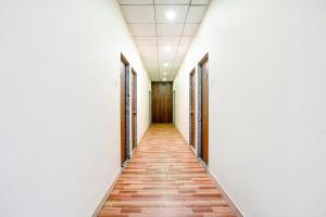 an empty corridor in an office building with a long hallway at FabHotel Gokuldham in Surat