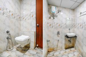 a bathroom with a toilet and a sink at FabHotel Gokuldham in Surat