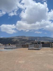 a building under construction with mountains in the background at house of the cloud jabal shams in Sa‘ab Banī Khamīs
