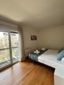 1 dormitorio con cama y ventana grande en Ulia Apartments- Garden Boutique, en San Sebastián