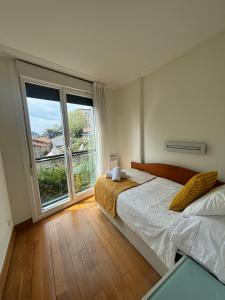 una camera con un letto e una grande finestra di Ulia Apartments- Garden Boutique a San Sebastián