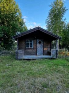 uma pequena cabana no meio de um campo de relva em Ofvansjö Gård , Enkel stuga för övernattning på ett fd militärområde em Sandviken